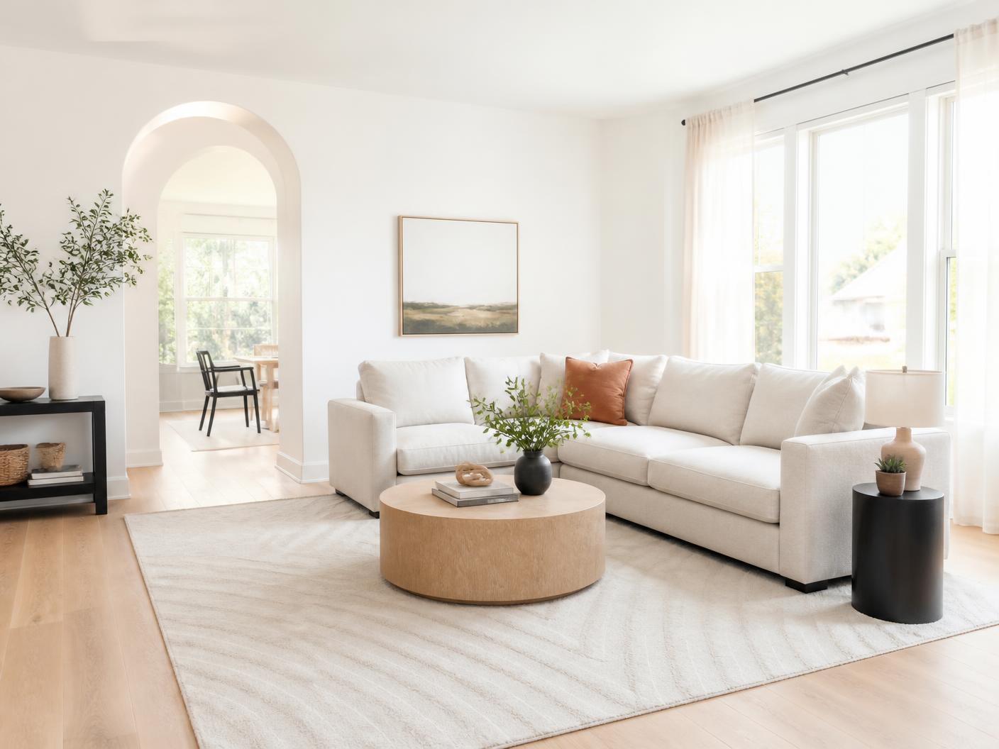 Airy living room with spotless floors and styled cushions after a house cleaning