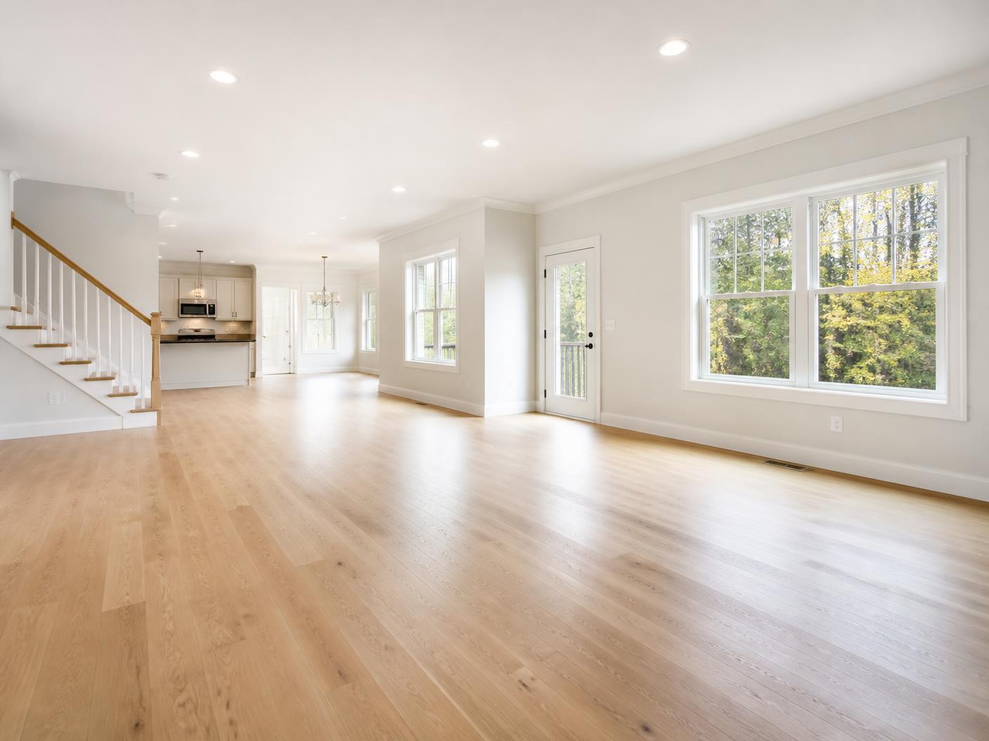 Empty living room with gleaming hardwood floors after a move-out clean